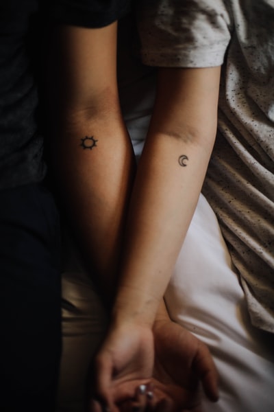 两个人展示他们的手纹身
